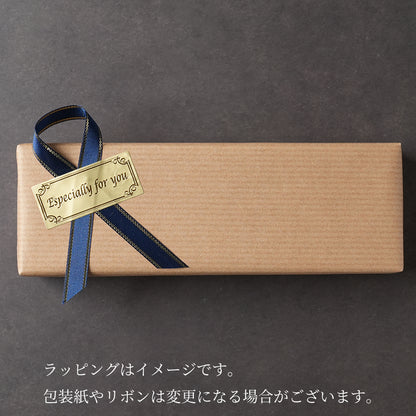 木軸ペンのギフトラッピング。男女問わず喜ばれる紺色のリボンに金色のシール。薄茶色のシンプルで上品なギフト包装。